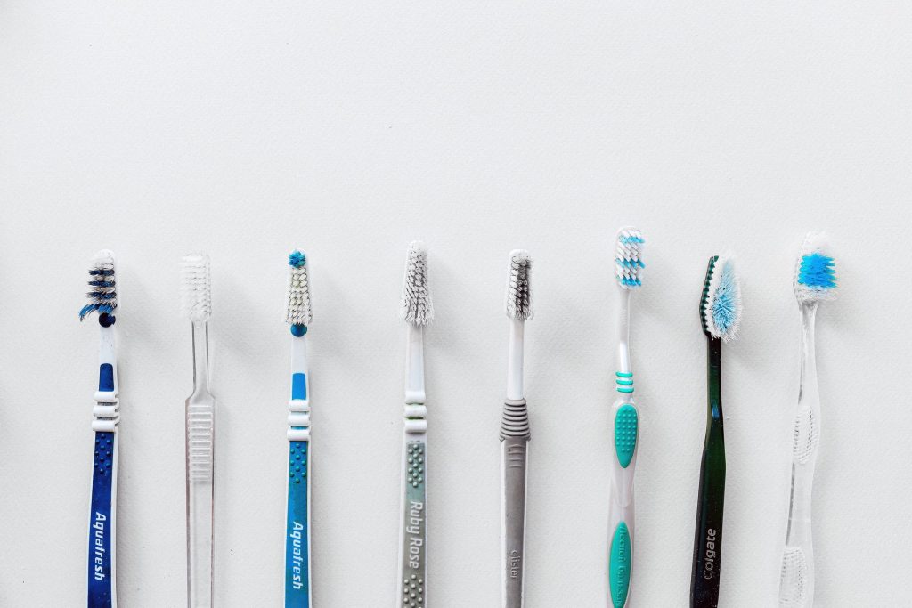 Assorted toothbrushes lined up beside each other.
